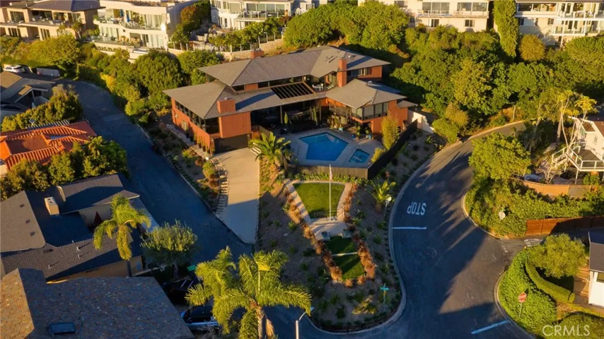 This aerial view captures the grandeur of this nearly 7,000 sq ft estate on a sprawling 17,600 sq ft lot, nestled in coveted Mystic Hills. Centered around a private full-size pool and extra-large spa, the home commands panoramic ocean vistas from its prominent corner position—offering seclusion, luxury, and endless coastal charm.