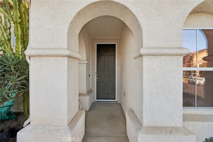 Covered front entry with an inviting arched walkway