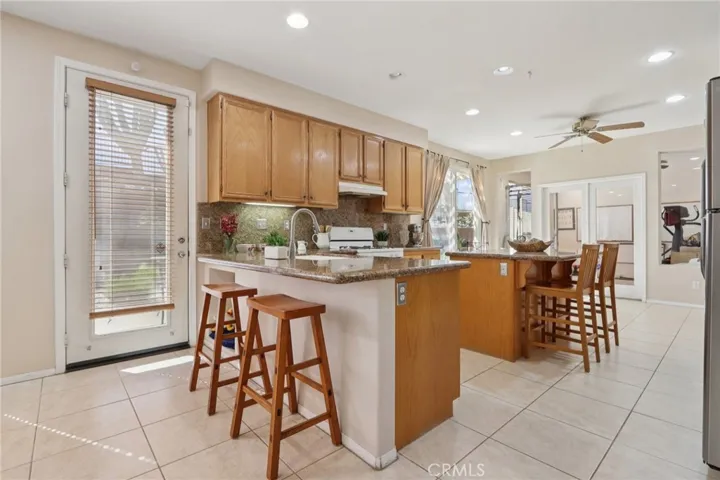 Kitchen with breakfast bar seating and open flow to the family room