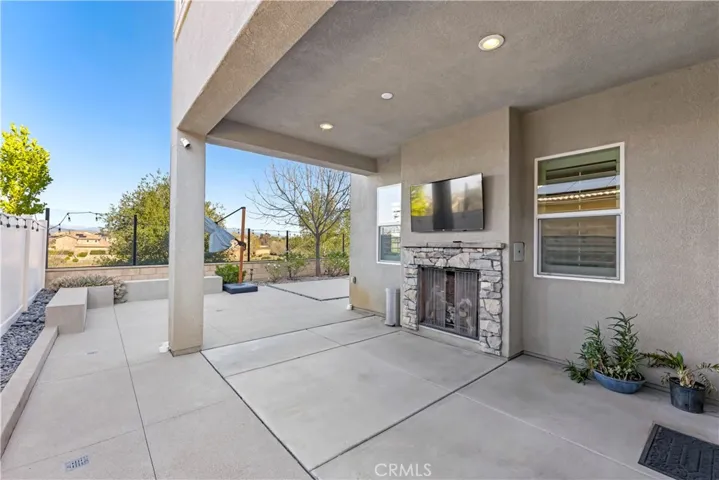 covered patio with fire place and TV