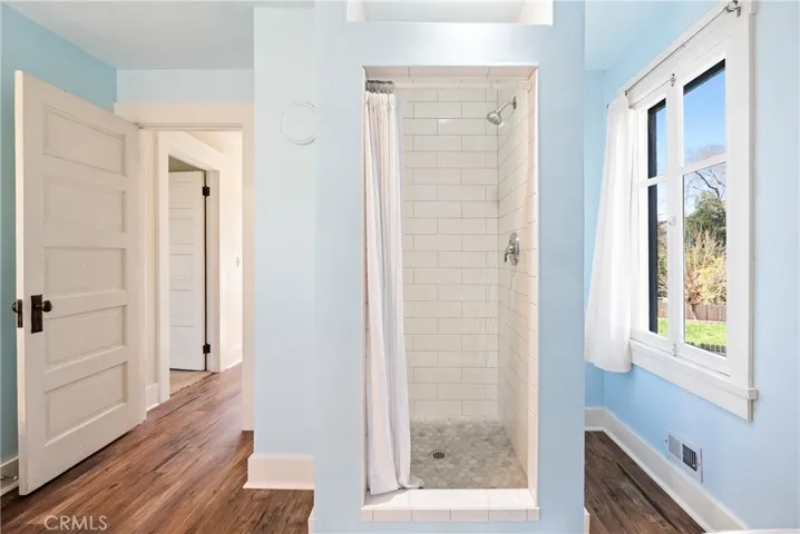 The handsome shower features white subway tile and a niche for your shower items.