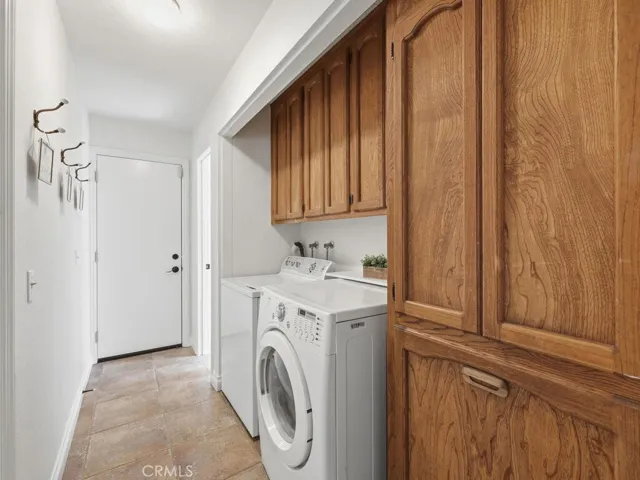 Indoor laundry area in hallway with access to rear yard