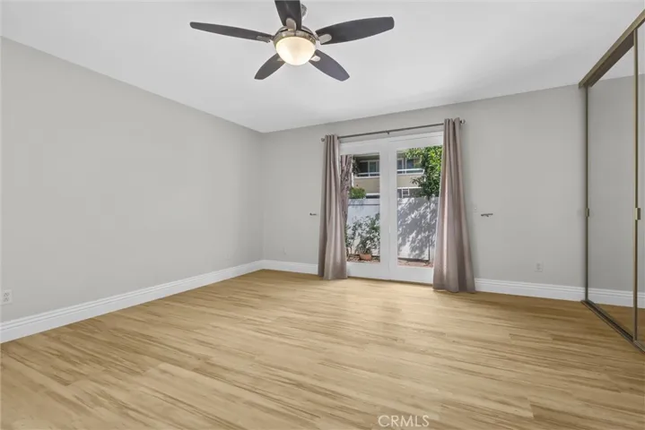 Primary 1 Bedroom with new floorings, drapes, ceiling fans/lights, large 3 mirrored closet doors with organizers   and access door to the enclosed backyard