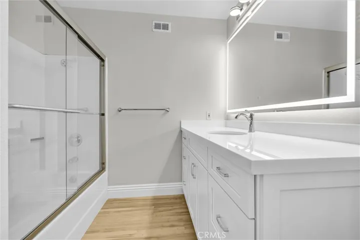 Primary bath #2, newly remodeled cabinets, quartz counter tops and backsplash, fixtures and lighted mirror, tub and shower