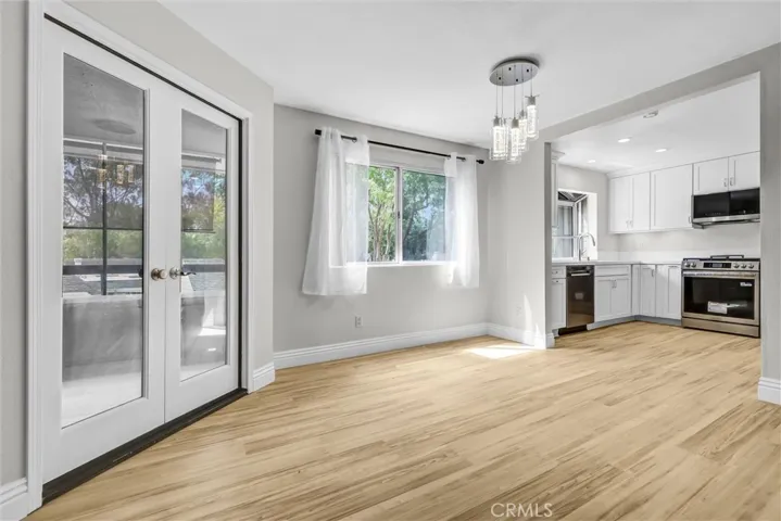 Dining area with drapes and blinds and double door access to view balconies