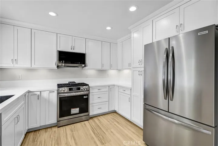 Newly upgraded kitchen quartz counter tops and backsplash with stainless Gas range, oven, microwave and Refrigerator plus dishwasher