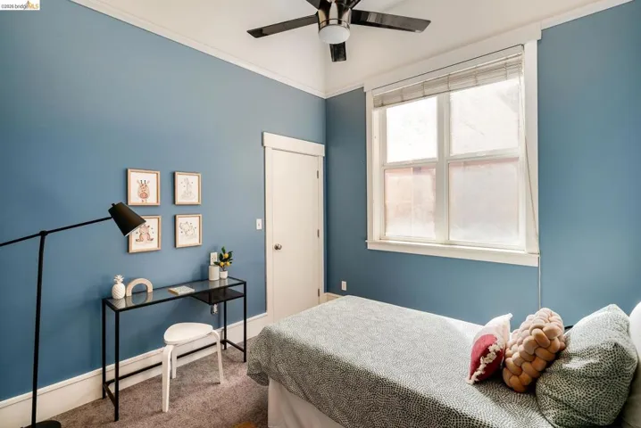 Carpeted bedroom with ornamental molding and a ceiling fan