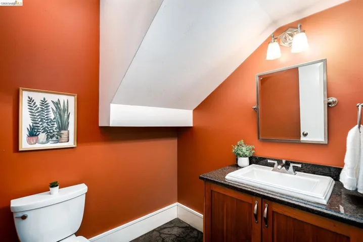 Half bath with vanity and lofted ceiling
