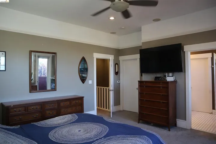 Carpeted bedroom featuring ceiling fan and recessed lighting