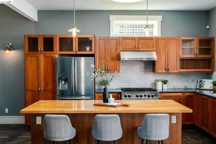 Kitchen with glass insert cabinets, wood finish cabinets, and stainless steel appliances