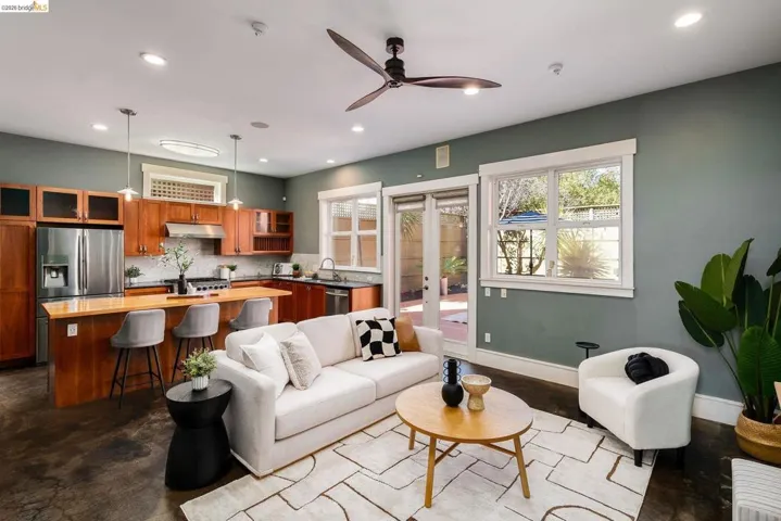 Living room with finished concrete floors, french doors, ceiling fan, and recessed lighting