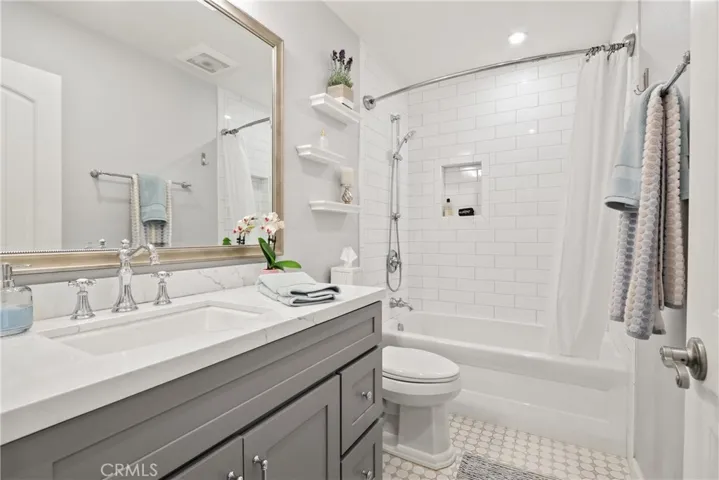 Hall bath with quartz counter and tiled shower/tub