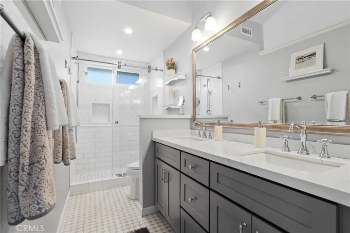 Master bath with double sink vanity and tiled shower