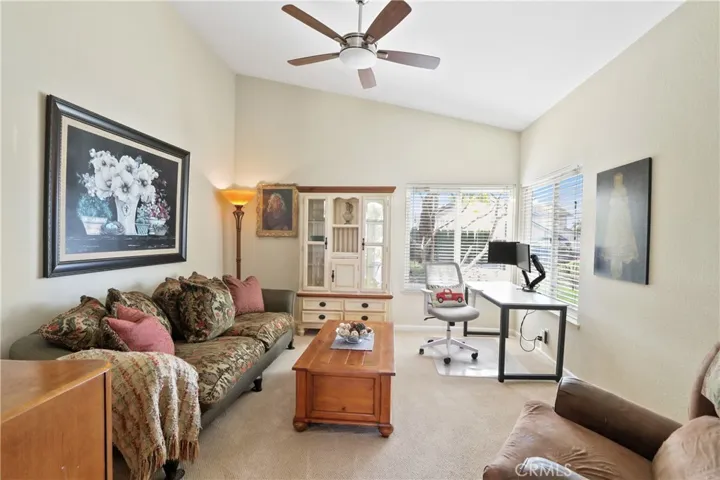 Living room with vaulted ceiling and fan