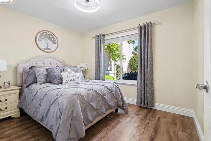 Bedroom with dark wood-type flooring and baseboards