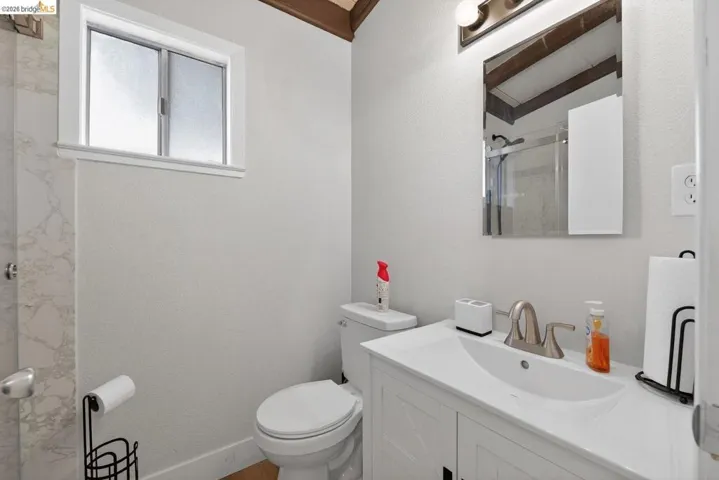full bathroom featuring vanity, lofted ceiling, and an enclosed shower