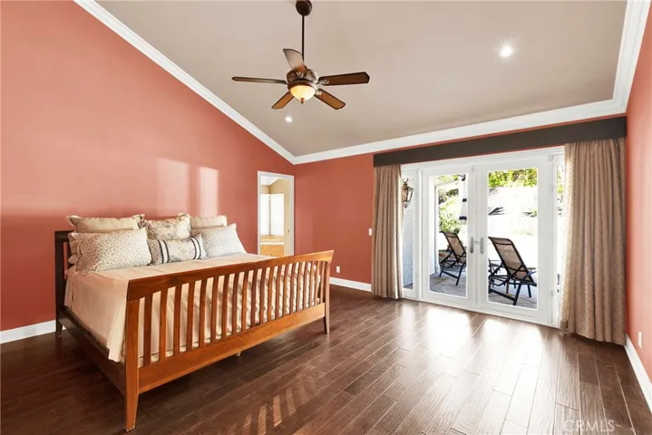 Primary Bedroom Suite with Vaulted Ceilings, Crown Molding, Ceiling Fan and Light, Custom Wood Flooring, Recessed Lights, and new Vinyl Sliding Door to backyard patio pool spa.