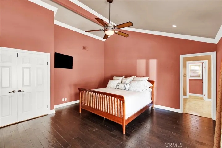 Primary Bedroom Suite with Vaulted Ceilings, Dual Custom Panel Doors, Crown Molding, Ceiling Fan and Light, Custom Wood Flooring, Recessed Lights, Flush Mount TV and in wall wire mount. Access to primary suite bath.