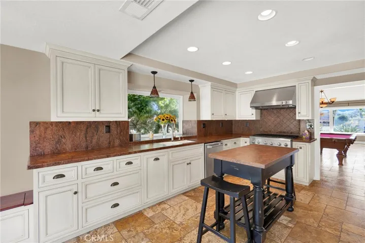 Remodeled kitchen with custom cabinets and countertops. Vaulted Ceilings and recessed lighting. Pendant Drop Lights over sink. Garden Window to back yard. Center Island Table is not attached to floor.