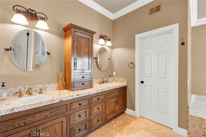 Upgraded Primary Suite Vanities and Center Counter Storage, Custom Mirrors and hardware, Crown Molding, Custom Panel Doors and Hardware.