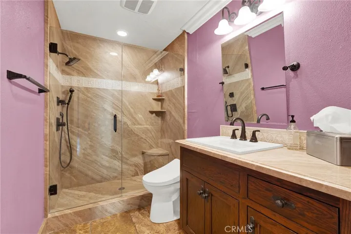Guest Bathroom upgraded to walk-in shower, frameless glass doors. upgraded vanity, mirrors and Crown molding.