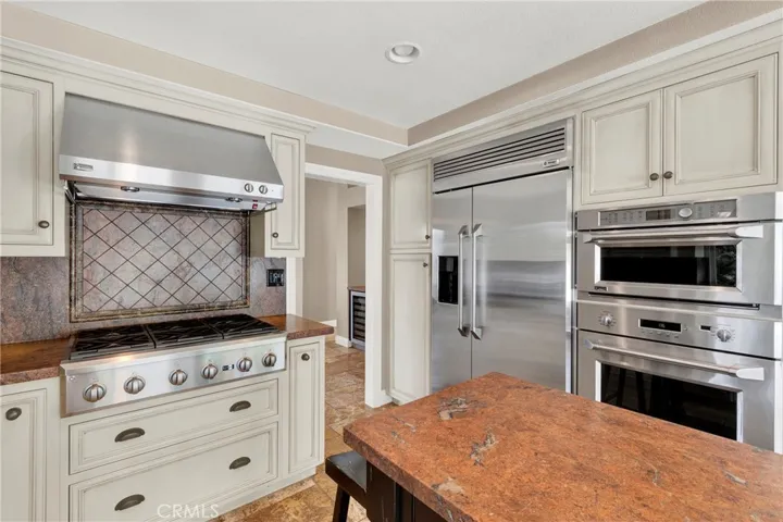 Up close detailed view of custom stainless steel kitchen appliances. Center wood island is NOT attached to the floor.
