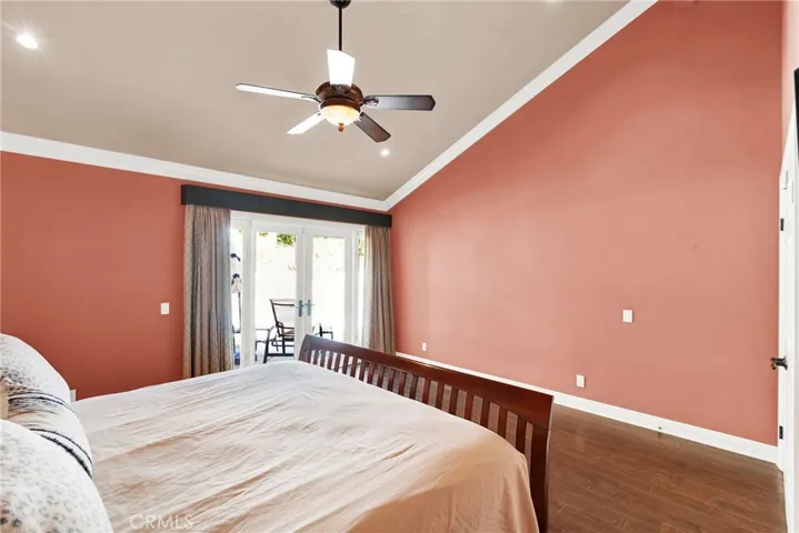 Primary Bedroom Suite with Vaulted Ceilings, Crown Molding, Ceiling Fan and Light, Custom Wood Flooring, Recessed Lights, and new Vinyl Sliding Door to backyard patio pool spa.