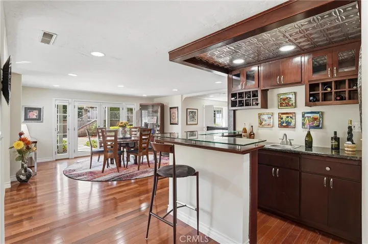 Beautiful, custom bar conveniently situated between the dining and conversation rooms.