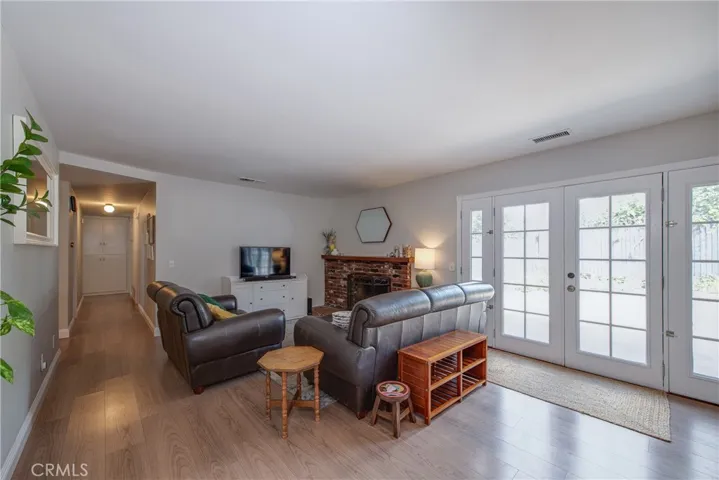 The French doors in the living room open to the large backyard, creating a seamless indoor-outdoor living experience.