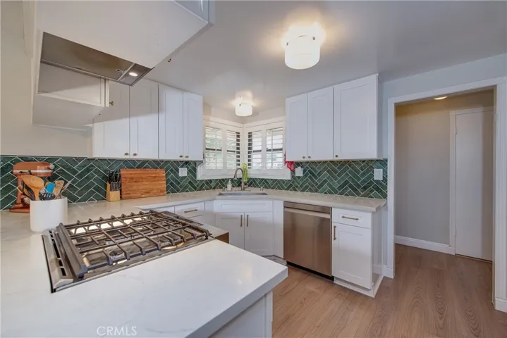 The white quartz countertop is highlighted by the beautiful green subway tile.