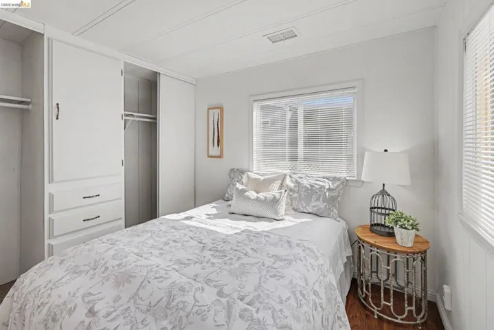Bedroom featuring dark wood-type flooring, a closet, and multiple windows