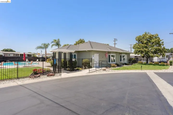 Ranch-style home with roof with shingles and a residential view