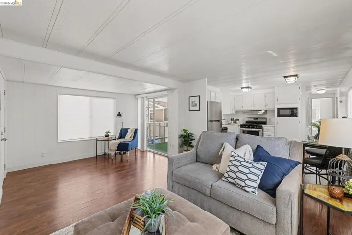 Living room featuring wood-type flooring and beamed ceiling
