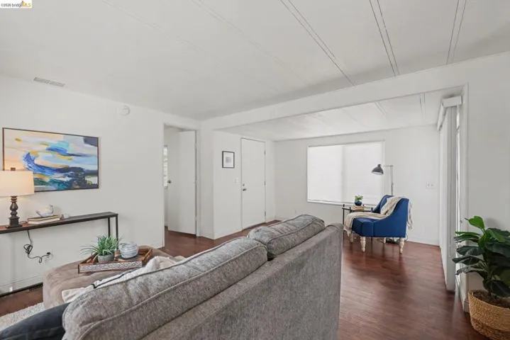Living room with dark wood-type flooring and baseboards