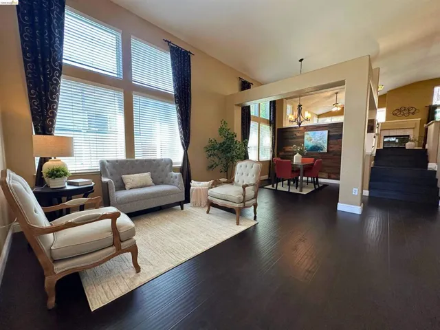 Living room with hanging lights, vaulted ceiling, and dark wood-type flooring