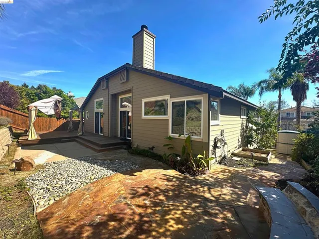 Rear view of house featuring a deck, a fenced backyard, and a chimney