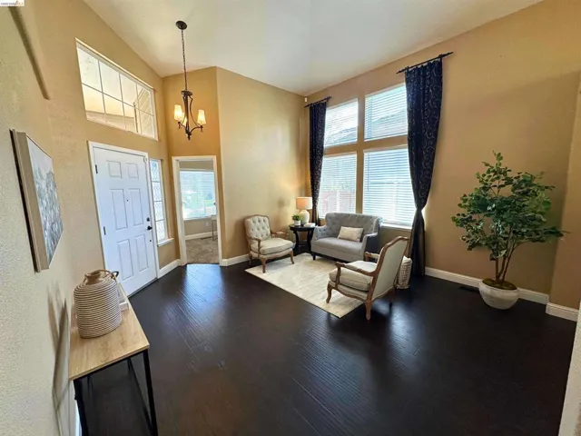 Entryway with suspended lighting, a high ceiling, healthy amount of natural light, and wood finished floors