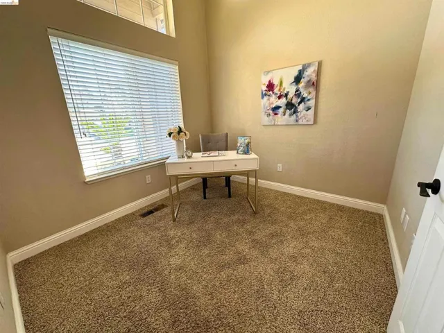 Carpeted office space with baseboards
