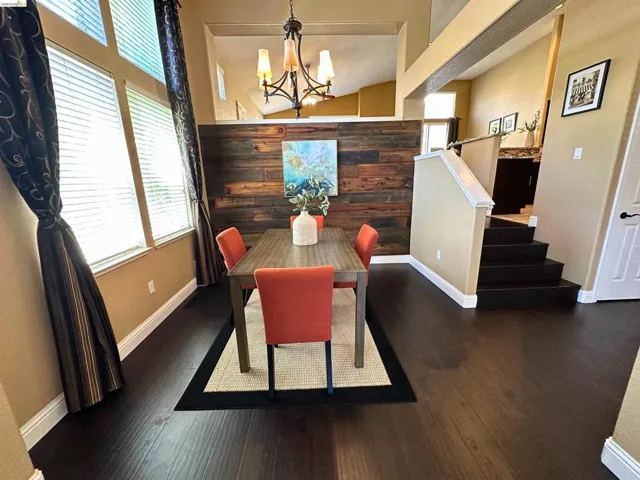 Dining room with a chandelier and dark wood-type flooring