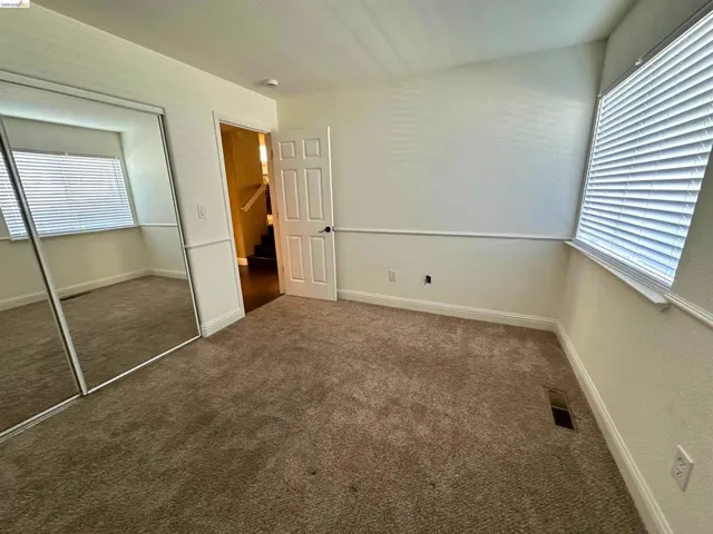 Unfurnished bedroom featuring dark carpet and a closet