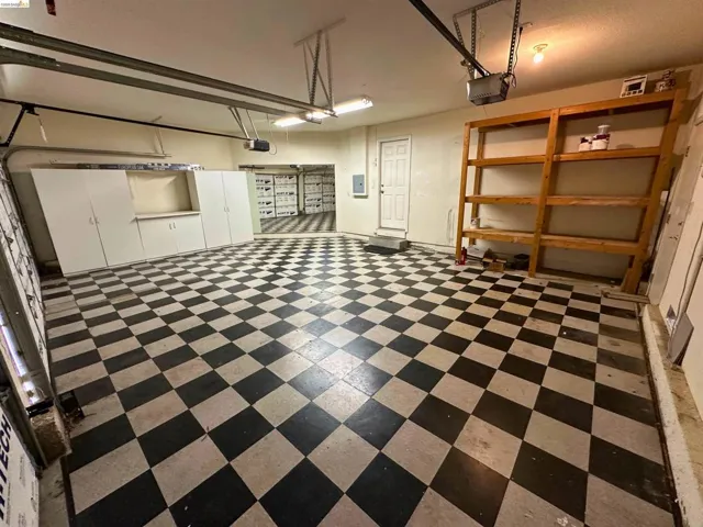 Garage featuring a garage door opener and electric panel