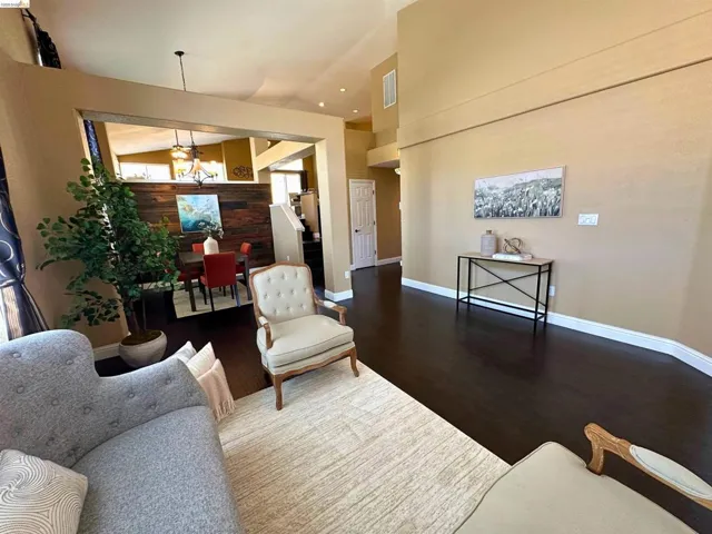 Sitting room with dark wood-type flooring, a chandelier, and a high ceiling