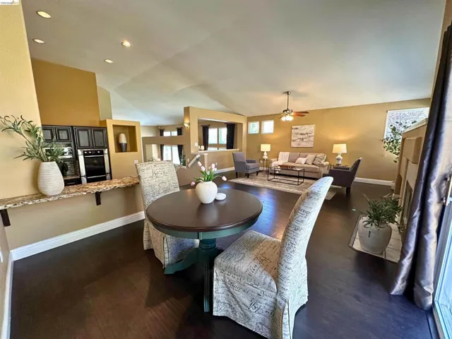 Dining area with dark wood-type flooring, a ceiling fan, lofted ceiling, and recessed lighting