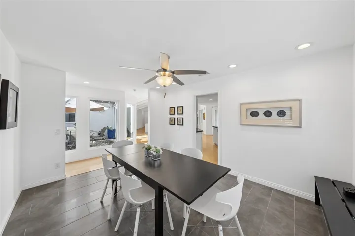 Enclosed patio retreat provides a private outdoor extension of the home, complete with deck seating area and overhead string lights for added ambiance.