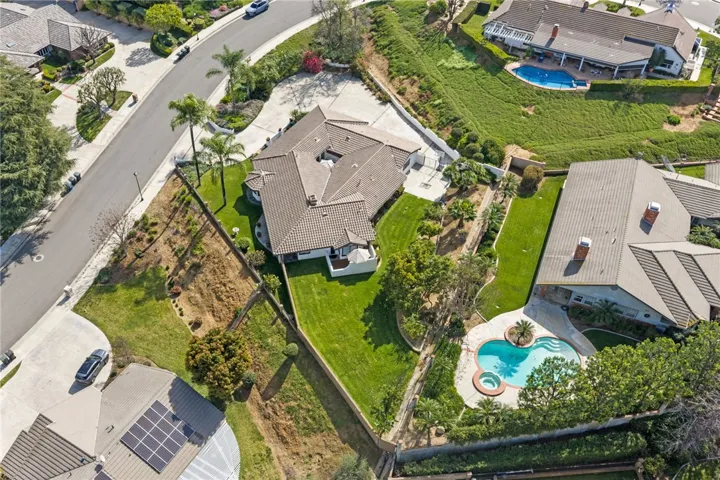 Overhead lot view highlights the home’s spacious yard, patio areas, and prominent position on the parcel. The layout offers a strong blend of indoor-outdoor living and usable outdoor space.