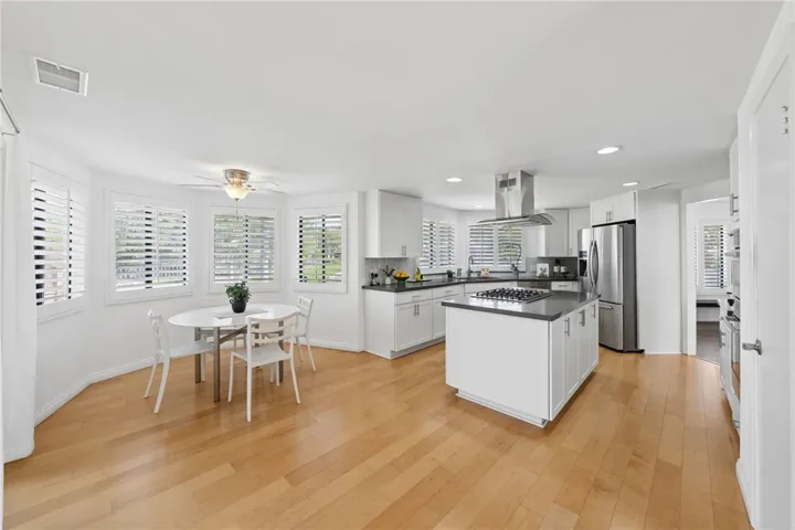 Sunny breakfast nook sits just off the kitchen, framed by surrounding windows and plantation shutters. The open layout provides a comfortable setting for casual dining.