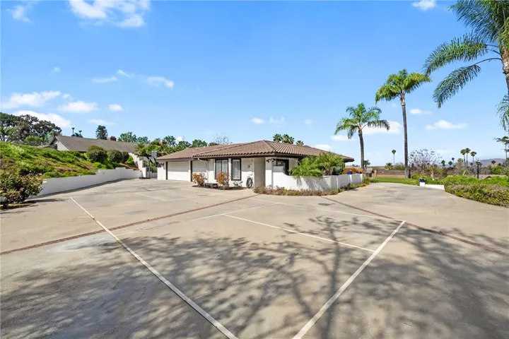 Driveway and Garage – Oversized driveway offers abundant parking and easy access, with the home’s broad footprint and corner-lot layout on full display.