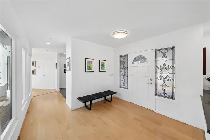 Spacious foyer showcases clean lines, updated flooring, and decorative glass sidelights that bring in soft natural light.