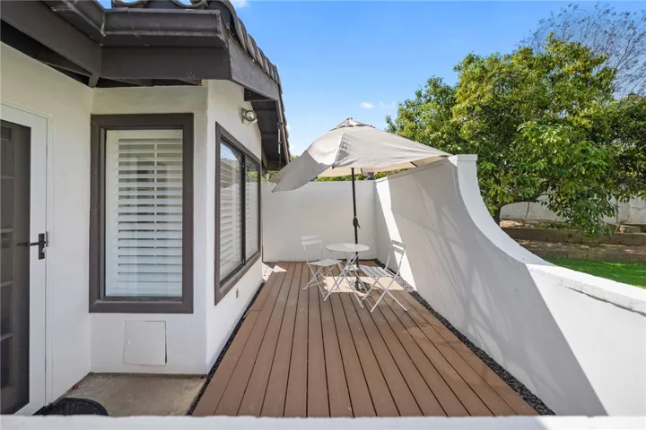 Tucked along the side of the home, this private deck-style patio offers a quiet spot for morning coffee or casual outdoor seating.