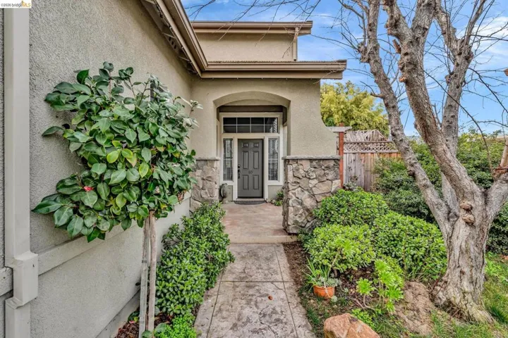 Property entrance featuring stucco siding and stone siding